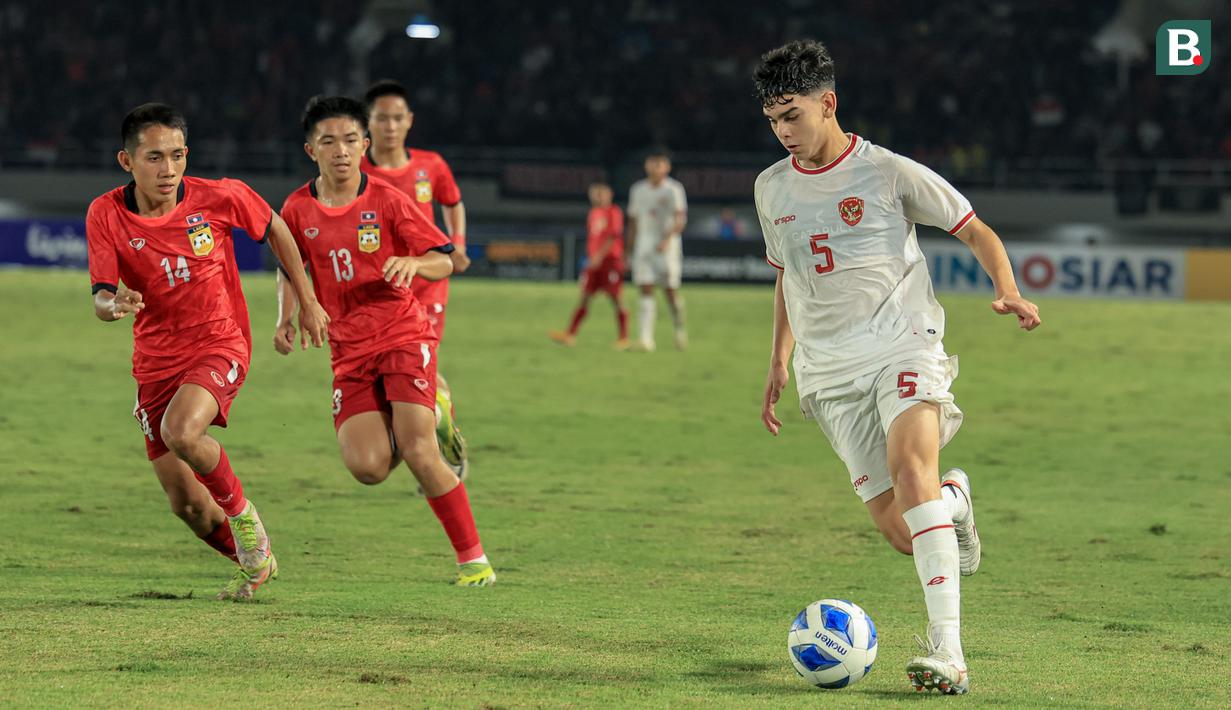 Pemain Timnas Indonesia U-16, Mathew Ryan Baker, menggiring bola saat melawan Laos dalam laga terakhir Grup A Piala AFF U-16 2024 di Stadion Manahan Solo, Kamis, (27/6/2024). (Bola.com/Radifa Arsa)