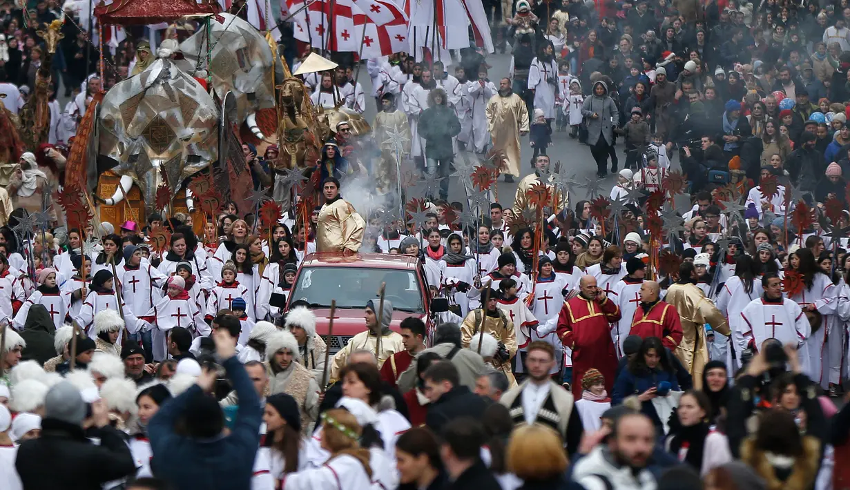 Sejumlah peserta "Alilo" saat melakukan pawai bersama di jalanan Tbilisi, Georgia, Kamis (7/1). Mereka merayakan Natal Ortodoks yang jatuh pada 7 Januari menurut kalender Julian. (REUTERS/David Mdzinarishvili)