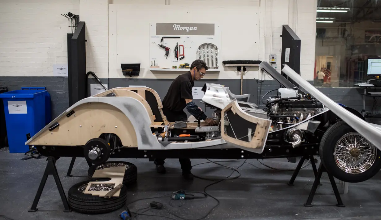 Pekerja menyelesaikan pembuatan mobil klasik dengan bahan dasar kayu ash di pabrik mobil Morgan Motor Company di Malvern, Birmingham, Inggris (13/8/2019). Produksi mobil klasik ini masih menggunakan cara manual tanpa dibantu robot. (AFP Photo/Oli Scarff)