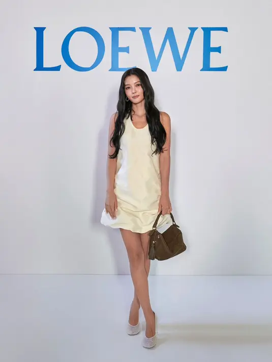 Aktris asal Korea Selatan Kim Yoo-jung mencuri perhatian lewat tampilannya yang feminin sekaligus modern. Ia mengenakan mini dress putih dengan siluet sederhana namun berkelas, dipadukan dengan Puzzle Bag berwarna cokelat,  salah satu ikon Loewe yang langsung menambah kesan timeless pada keseluruhan look-nya.