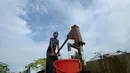 Seorang pemuda Rohingya mengumpulkan air minum dari sumur di kamp Kutupalong, di Ukhia, Bangladesh pada 6 Oktober 2020. Lebih dari satu juta etnis Rohingya melarikan diri dari Myanmar dan menetap di Kutupalong yang merupakan salah satu kamp pengungsi terbesar di dunia. (Munir Uz Zaman/AFP)