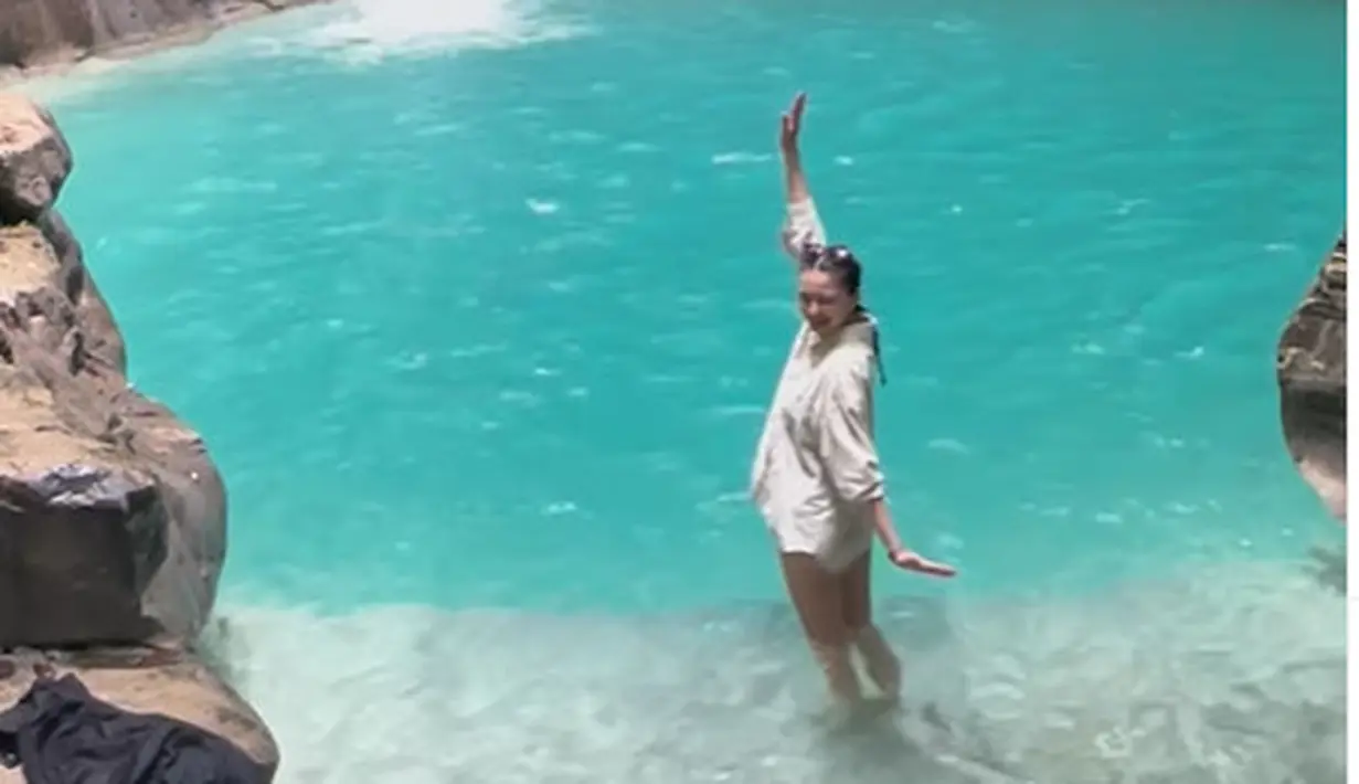 Berenang di bawah air terjun yang bening, Raline Shah kenakan bikini hitam berlapis kemeja linen [@ralineshah]