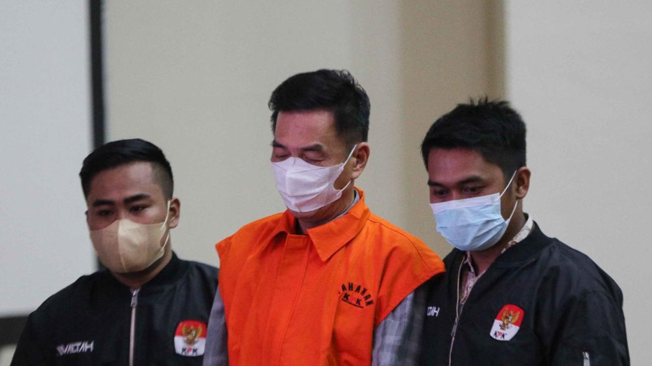 Dikawal oleh dua petugas penyidik KPK, Komisaris Utama PT Multi Grafika Cipta Sejati Mulsunadi Gunawan (MG) yang diborgol saat dihadirkan dalam konferensi pers di Gedung KPK, Jakarta, Senin (31/7/2023).