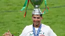 Cristiano Ronaldo bergaya dengan tropi Piala Eropa 2016 usai mengalahkan Prancis 1-0 di Stade de France, Senin (11/7). Ronaldo menjadi pemain yang tampil paling banyak sepanjang perhelatan Piala Eropa berlangsung sebanyak 21 kali. (REUTERS)