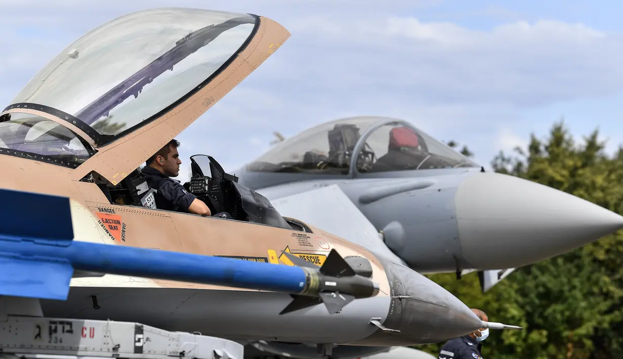 Teknisi Israel duduk dalam kokpit jet F16 (kiri) di samping Eurofighter, Noervenich, Jerman, Kamis (20/8/2020). Pilot Israel dan Jerman akan terbang bersama selama dua minggu ke depan selama latihan Angkatan Udara gabungan pertama di Jerman. (AP Photo/Martin Meissner)