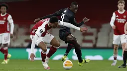 Bek Arsenal, Gabriel berebut bola dengan pemain Slavia Praha, Abdallah Sima pada pada pertandingan leg pertama perempat final Liga Europa di Stadion Emirates di London, Jumat (9/4/2021). Arsenal bermain imbang atas Slavia Praha 1-1.  (AP Photo/Alastair Grant)