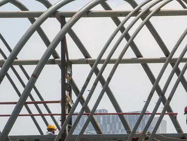 Aktivitas pekerja saat menyelesaikan pembangunan Jembatan Penyeberangan Orang (JPO) di jalan KH Mas Mansyur, Tanah Abang, Jakarta Pusat, Senin (23/9/2024). (Liputan6.com/Angga Yuniar)