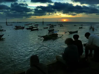 Warga memancing ikan saat matahari terbenam di Pantai Kedongnan, Bali, Senin (6/9/2021). Masa pandemi dimanfaatkan warga yang kehilangan pekerjaan untuk memancing, dimana hasilnya digunakan sebagai pelengkap lauk makan di rumah. (merdeka.com/Arie Basuki)