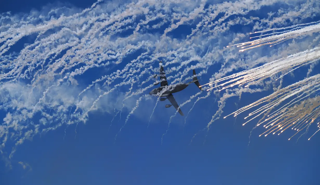 Sebuah jet kargo militer Emirat terbang melalui asap setelah melepaskan sekam selama aksi di Dubai Air Show di Dubai, Uni Emirat Arab (14/11/2021). Di acaraini industri pewsawat terbang memamerkan hasil karya mereka, tak terkecuali Boeing dan Airbus. (AP Photo/Jon Gambrell)