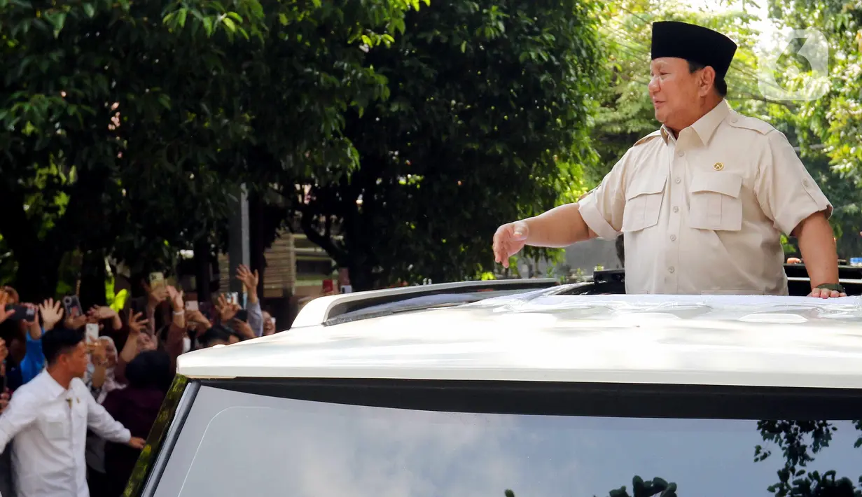 Dari sunroof mobilnya, Presiden Prabowo juga menyapa warga yang berkerumun di pinggir jalan. (Liputan6.com/Herman Zakharia)