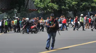 Salah satu pelaku penembakan di persimpangan Sarinah, Jalan MH Thamrin, Jakarta, tertangkap kamera, Kamis (14/1). Pelaku mengeluarkan senjata di tengah kepanikan warga pasca ledakan bom. (REUTERS/Veri Sanovri/Xinhua)