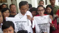  Anggota DPR Rieke Diah Pitaloka memberikan kaos dukungan TKI Satinah kepada Gubernur DKI Jokowi. (Liputan6.com/Luqman Rimadi)