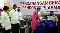 Ketua Umum PMI Jusuf Kalla (kiri) menyaksikan Menko Perekonomian Airlangga Hartarto (kanan) yang sedang melakukan donor plasma konvalesen saat Pencanangan Gerakan Nasional Pendonor Plasma Konvalesen di Markas PMI, Jakarta, Senin (18/1/2021). (StaffJK/Ade Danhur)