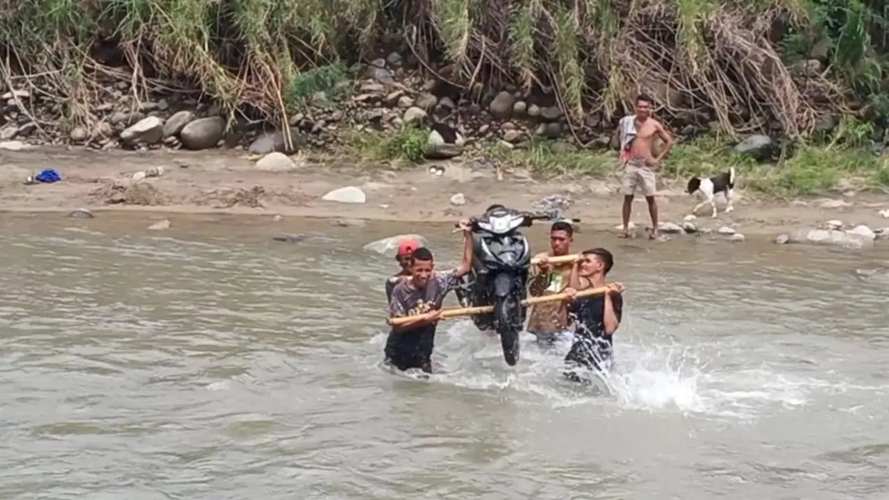 Warga Desa Korobhera gunakan jasa pikul motor saat menyebrang di sungai. (Liputan6.com/Dionisius Wilibardus)