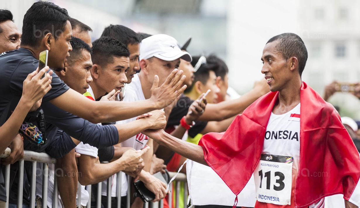 Pelari Indonesia, Agus Prayogo, menyapa suporter usai tampil pada nomor marathon SEA Games di Putrajaya, Kuala Lumpur, Sabtu (19/8/2017). Agus meraih medali perak dengan waktu dua jam 27 menit 16 detik. (Bola.com/Vitalis Yogi Trisna)