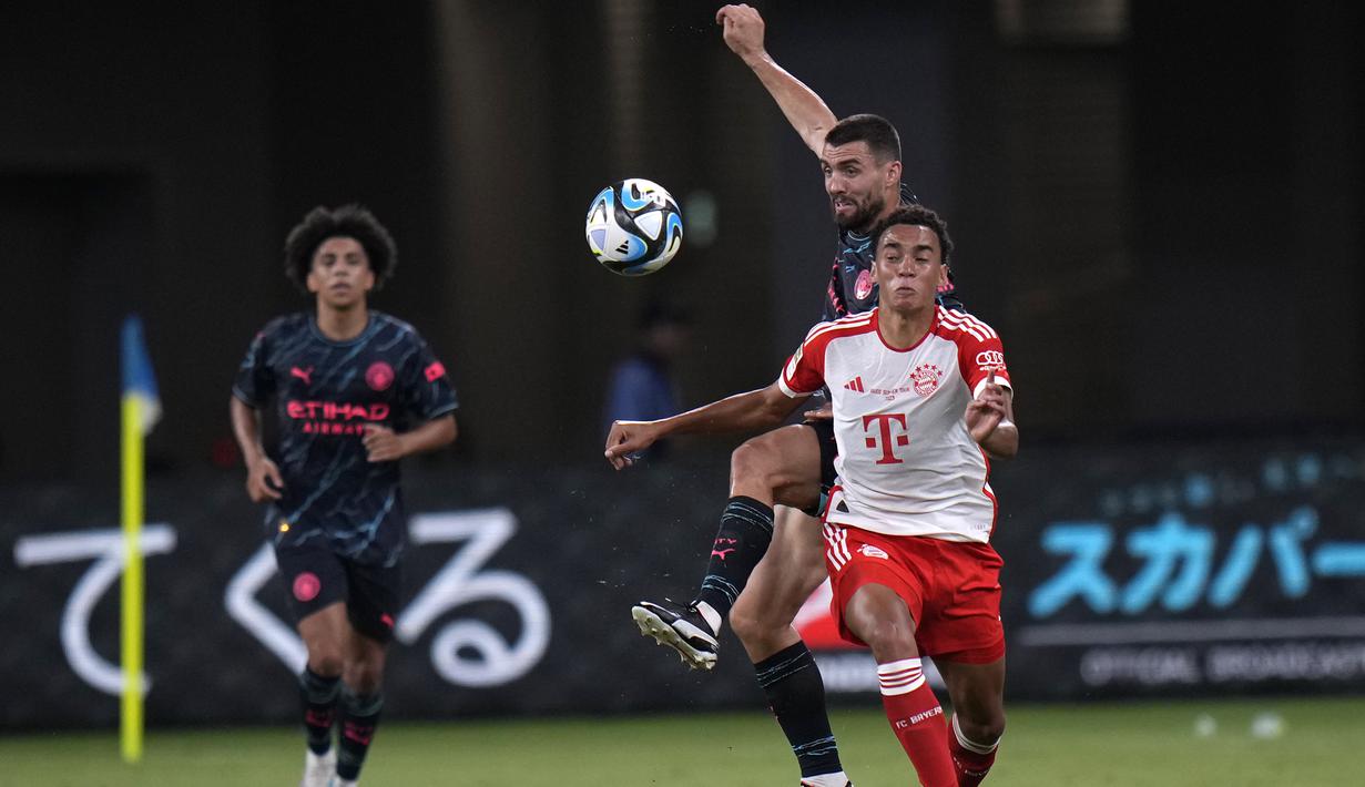Gelandang Bayern Munchen, Jamal Musiala (depan) berebut bola dengan gelandang Manchester City, Mateo Kovacic pada laga pramusim 2023/2024 bertajuk Audi Football Summit di Stadion Nasional Tokyo, Jepang, Rabu (26/7/2023) malam WIB. (AP Photo/Shuji Kajiyama)