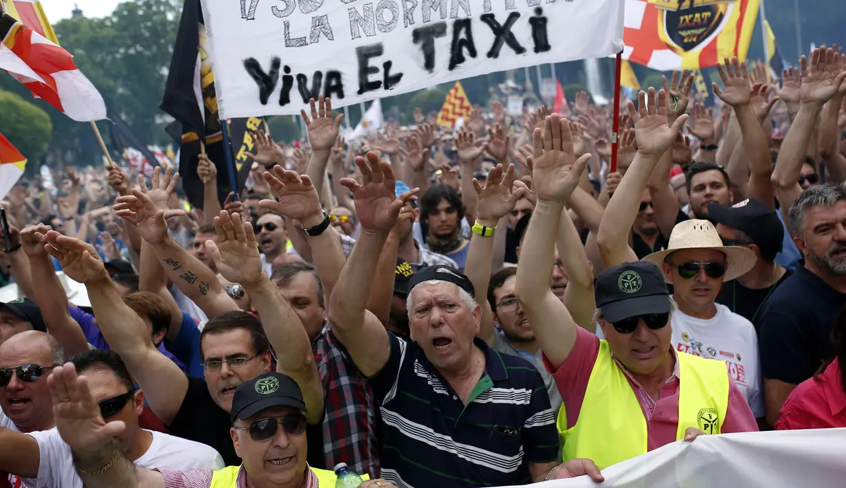 Sejumlah orang yang tergabung dalam Serikat Pekerja Taksi Spanyol menggelar demonstrasi di Madrid, Spanyol, Selasa (30/5). Sopir taksi Spanyol  memprotes layanan mobil berbasis online karena harganya terlalu murah. (AP Photo / Francisco Seco)