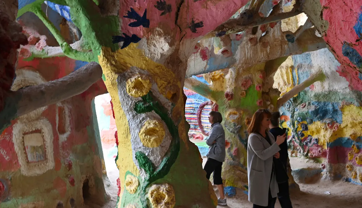 Wisatawan menjelajahi labirin buatan saat mengunjungi Salvation Mountain, sebuah lereng bukti di Niland, California, AS. Dibuat oleh penduduk lokal bernama Leonard Knight, Salvation diisi dengan banyak seni lukis berupa mural dengan kutipan Kristen dan ayat-ayat Alkitab. (Robyn Beck/AFP)