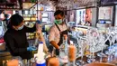 Bartender Gagan (kanan) dan seorang pelayan membersihkan bar jelang pembukaan kembali di New Delhi, 8 September 2020. Setelah sebelumnya ditutup karena pandemi COVID-19, mulai 9 September 2020 New Delhi mengizinkan bar kembali buka dengan kapasitas tempat duduk 50 persen. (Prakash SINGH/AFP)