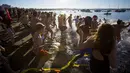 Orang-orang berlari menuju pantai untuk ambil bagian dari acara tahunan Polar Bear Swim di Vancouver, Kanada (2/1/2016). Meski suhu di pantai tersebut mencapai 3 derajat celcius, mereka tetap antusias. (REUTERS / Ben Nelms)