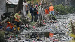Petugas kebersihan membersihkan sampah di Kali Bahagia, Bekasi, Jawa Barat, Kamis (1/8/2019). Ratusan petugas gabungan dikerahkan untuk membersihkan Kali Bahagia. (AP Photo/Tatan Syuflana)