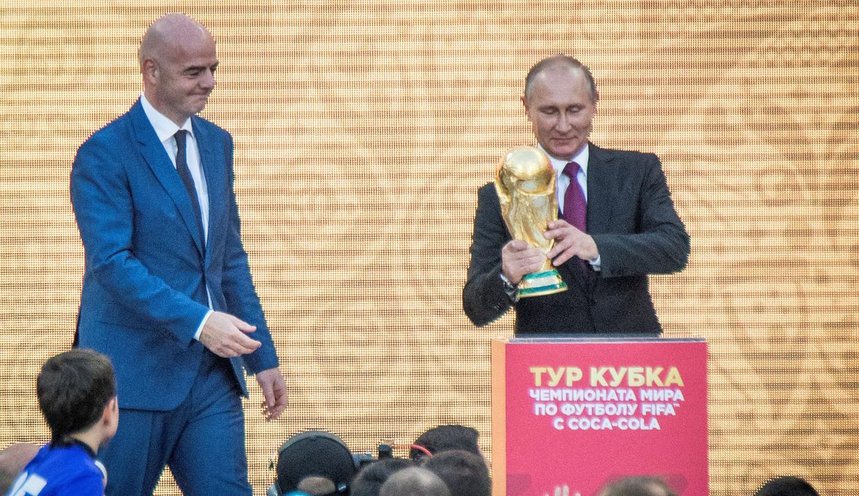 Presiden Rusia Vladimir Putin dan Presiden FIFA, Gianni Infantino bersiap menaruh trofi Piala Dunia dalam pembukaan upacara  "FIFA World Cup Trophy Tour" di stadion Luzhniki di Moskow (9/9). (AFP Photo/Mladen Antonov) 