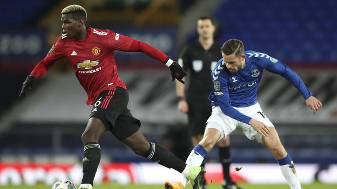 Gelandang Manchester United, Paul Pogba menggiring bola dari kawalan pemain Everton, Gylfi Sigurdsson babak perempat final di Goodison Park, Kamis (24/12/2020). MU tampil dominan di babak pertama. Namun tak ada gol yang tercipta selama 45 menit pertama. (AP Photo/Nick Potts,Pool)