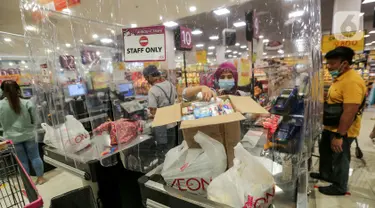 Kasir memasukan barang konsumen yang dibatasi dengan plastik di supermarket AEON Mall BSD City, Tangerang, Rabu (3/6/2020). Pembatasan tersebut dilakukan untuk memberikan jarak sosial dalam interaksi antara kasir dan konsumen selama pandemi Covid-19. (Liputan6.com/Fery Pradolo)