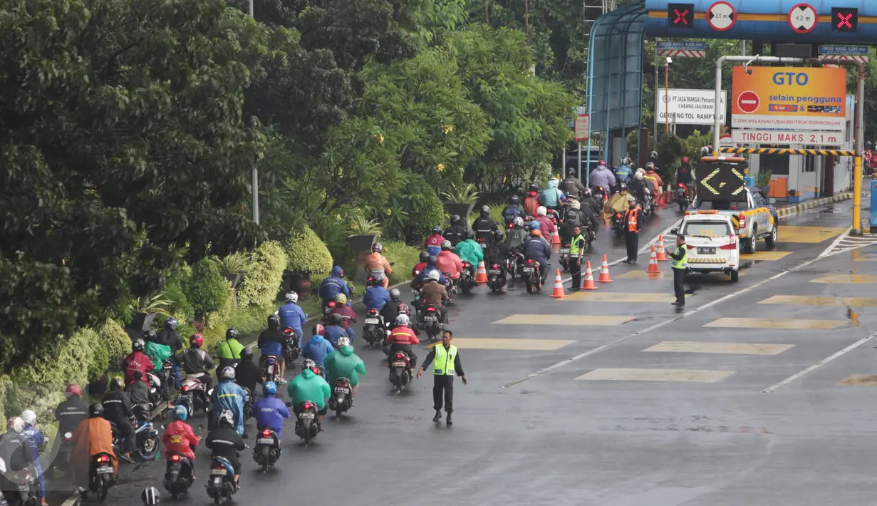 Petugas mengarahkan sejumlah pengendara sepeda motor masuk menuju tol dalam kota di pintu tol Taman Mini 2, Jakarta, Kamis (21/4). Hujan deras yang mengguyur sejak semalam membuat sejumlah jalan di Ibu Kota tergenang banjir. (Liputan6.com/Angga Yuniar)