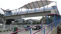 Pengendara melintas di bawah JPO Jelambar Barat di Jalan Pangeran Tubagus Angke, Jakarta, Sabtu (22/12). JPO Jelambar Barat memiliki atap berdesain modern dengan membran putih dengan model melengkung. (Liputan6.com/Helmi Fithriansyah)