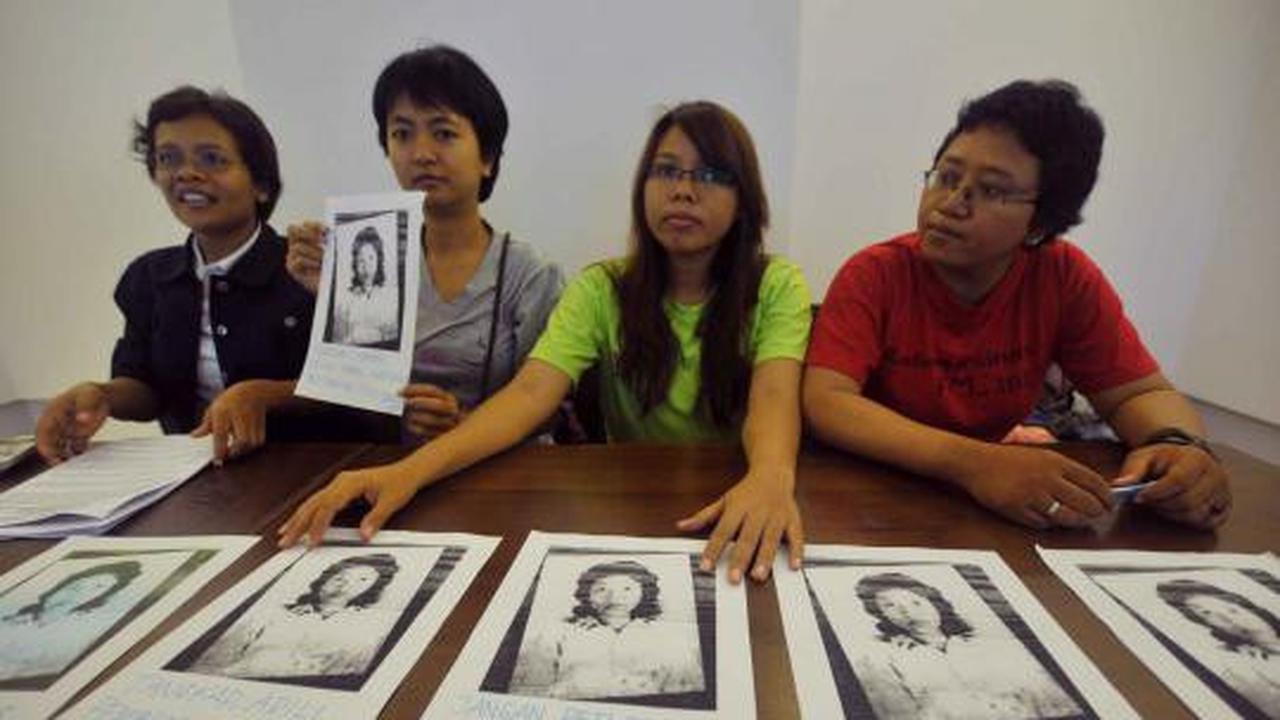 Seorang aktivis menuliskan pesan di foto Marsinah saat konferensi pers 