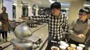 Seorang pria memberikan isyarat ke salah satu robot di restoran robot di Hefei, China, Jumat (26/12/2014). (REUTERS/Stringer)