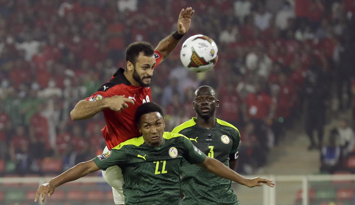 Striker Mesir, Marwan Hamdi (atas) berduel udara dengan bek Senegal, Abdou Diallo dalam laga final Piala Afrika 2021 di Stade d'Olembe, Yaounde, Kamerun (6/2/2022). (AP/Sunday Alamba)