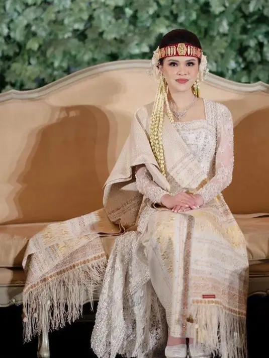 Disempurnakan dengan aksesori khas Batak seperti sortali merah dan bunga-bunga yang disematkan di rambutnya.  [IG/fcgweddings]