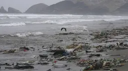 Akibat sampah yang berserakan air pantai berubah warna menjadi coklat karena tercemar. (AP Photo/Martin Mejia)