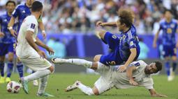 Pemain Iran, Shojae Khalilzadeh (kanan bawah) berebut bola dengan pemain Jepang, Ayase Ueda (kanan atas) pada laga perempat final Piala Asia 2023 di Education City Stadium, Al Rayyan, Sabtu (03/02/2024) WIB. (AP Photo/Hussein Sayed)