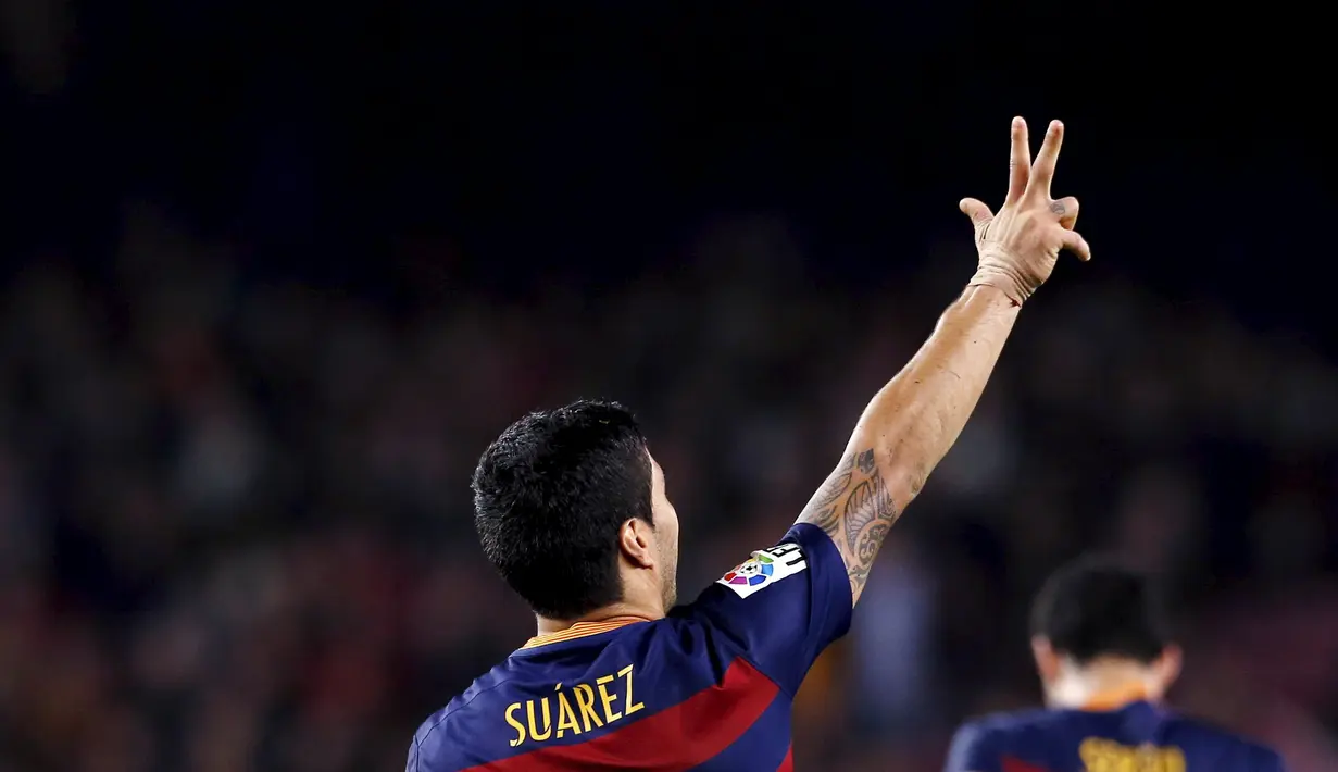 Tiga jari Luis Suarez merujuk pada tiga gol yang dia cetak ke gawang Eibar dalam laga La Liga Spanyol di Stadion Camp Nou, Barcelona, Senin (26/10/2015) dini hari WIB. (Reuters/Albert Gea)