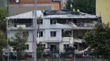 Sejumlah petugas menutupi kantor polisi dengan kain di Istanbul usai dibom, Senin (10/8/2015). Sebuah truk bermuatan bahan peledak membombardir kantor polisi yang melukai tiga anggota dan tujuh warga sipil. (REUTERS/Huseyin Aldemir)
