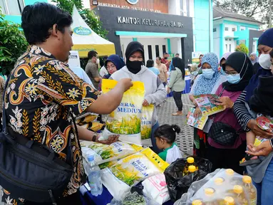 Warga membeli bahan kebutuhan pokok dengah harga di bawah harga eceran tertinggi (HET) saat kegiatan operasi pasar di Kantor Kelurahan Sawah, Tangerang Selatan, Banten, Kamis (29/9/2022). Dinas Perindustrian dan Perdagangan (Disperindag) Kota Tangerang Selatan menggelar operasi pasar di tujuh kecamatan dalam rangka penanganan inflasi sebagai dampak kenaikan harga bahan bakar minyak (BBM). (merdeka.com/Arie Basuki)