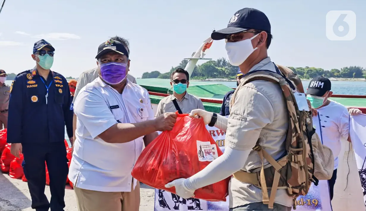 Ketua Paguyuban Perwira Abituren Akmil 95 Kolonel Inf Sumirating Baskoro secara simbolis memberikan donasi kepada Lurah Pulau Pari, Mahtum di Pulau Pari, Rabu (20/5/2020). Donasi berupa 2000 paket Sembako, 200 set APD, 1000 masker medis dan 50 pasang sarung tangan. (Liputan6.com/Pool/Damadika 95)