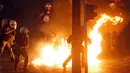 Polisi menghindari api bom molotov yang dilempar pengunjuk rasa anti-bailout di Athena, Yunani, Rabu (15/7/2015). Unjuk rasa ini dilakukan menjelang pemungutan suara kesepakatan bailout. (REUTERS/Jean-Paul Pelissier)