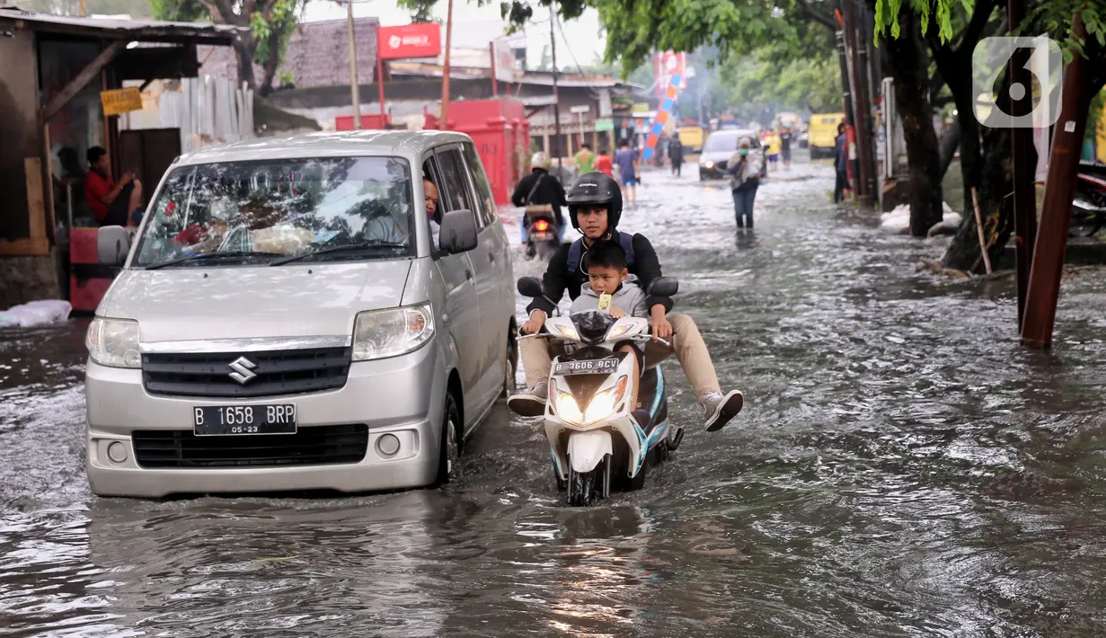 Kendaraan menerobos banjir yang menggenangi Jalan KH. Ahmad Dahlan Cipondoh, Tangerang, Selasa (16/2/2021). Hujan deras yang melanda wilayah Tangerang mengakibatkan ruas jalan alternatif penghubung Tangerang dengan Jakarta tersebut banjir setinggi lutut orang dewasa. (Liputan6.com/Angga Yuniar)