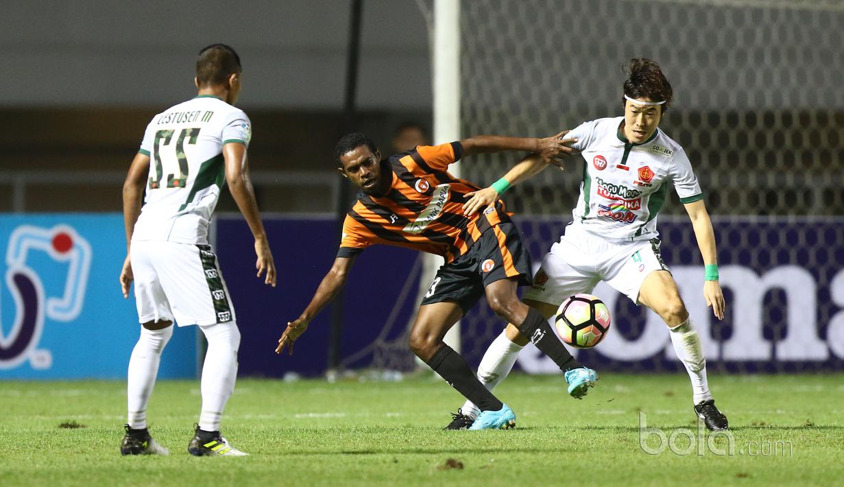 Pemain PS TNI, Hong Soon-hak berebut bola dengan pemain Perseru Serui, Franklin Rumbiak (tengah) pada laga Liga 1 2017 di Stadion Pakansari, Bogor, Minggu (18/6/2017). PS TNI menang 1-0. (Bola.com/Nicklas Hanoatubun)