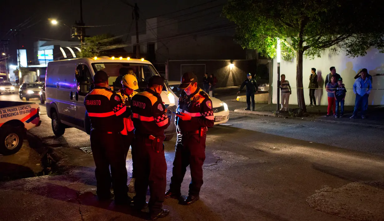 Sejumlah petugas keamanan berjaga di dekat lokasi garasi parkir bawah tanah yang runtuh di sebuah kompleks di Mexico City (10/4). (AP Photo/Rebecca Blackwell)