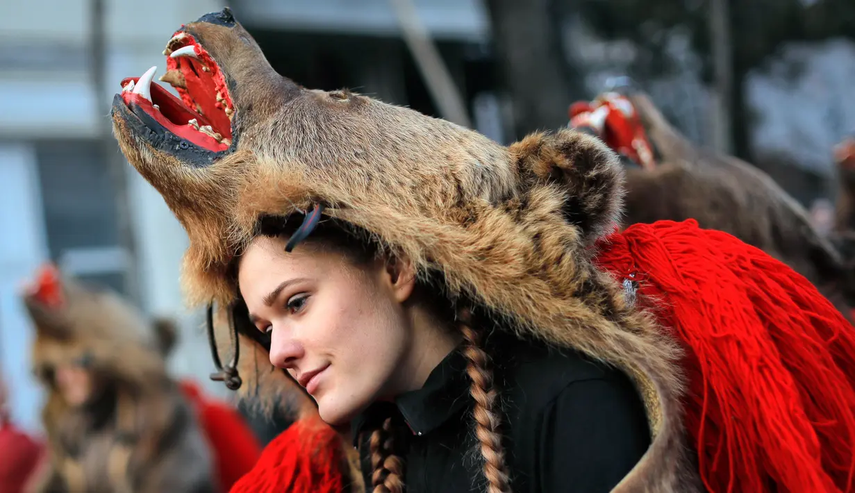 Seorang gadis mengenakan kostum beruang menari selama ritual tahunan di Piatra Neamt, Rumania Utara (28/12). Tradisi unik yang telah berusia ratusan tahun ini bertujuan untuk menangkal kejahatan. (AP Photo/Vadim Ghirda)