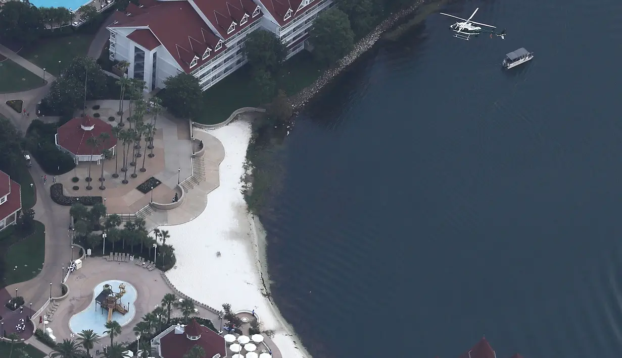 Helikopter melakukan pencarian di atas Walt Disney World Resort, Orlando, Rabu (15/6). Ayah sang bocah melihat buaya yang memiliki panjang 120-213 cm itu menerkam anaknya dan menyeretnya ke dalam danau. (Joe RAEDLE/GETTY IMAGES NORTH AMERICA/AFP)