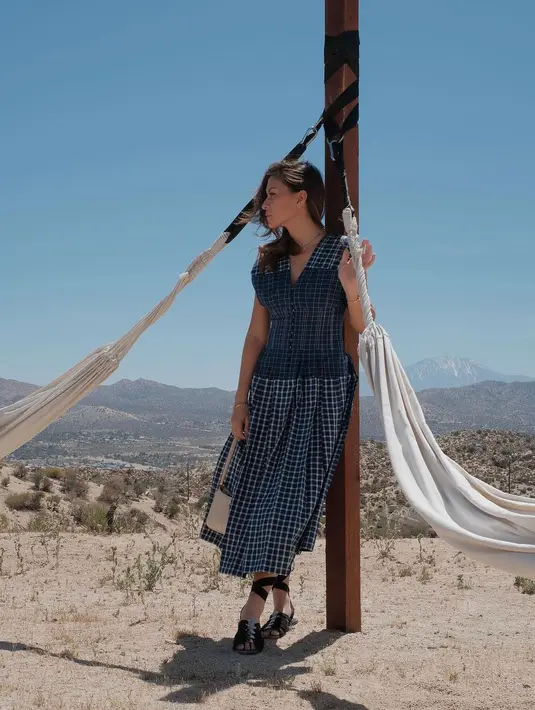 <p>Dress kotak - kotak berwarna navy akan cocok untuk outfitmu di California. (instagram/mariannerumantir)</p>