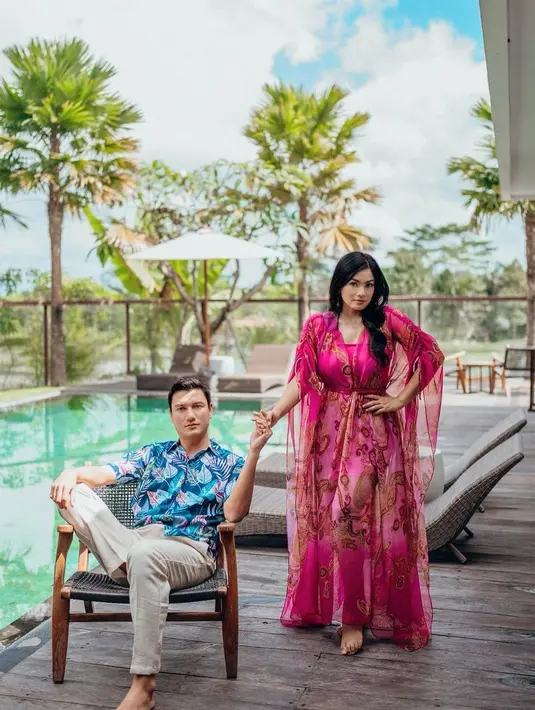 <p>Busana couple dari Titi Kamal dan Christian Sugiono bisa ditiru. Warna berbeda tetap memberi tampilan serasi yang cocok digunakan saat liburan musim panas. [Instagram/titi_kamall]</p>