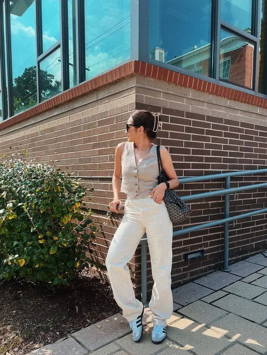 Enzy Storia tampil kasual dengan atasan cropped vest cokelat dan celana panjang taupe yang serasi. Penampilannya disempurnakan dengan sneakers putih, rambut digulung dengan penjepit, dan sunglasses. [Foto: Instagram/enzystoria]