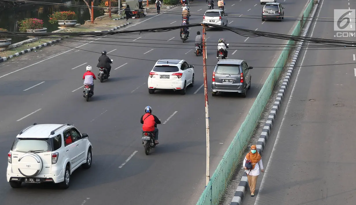 Seorang pejalan kaki melintas dibawah kabel yang ditopang tiang bambu di kawasan Pasar Baru, Jakarta, Selasa (12/9). Selain membahayakan pengguna jalan, buruknya instalasi kabel tersebut juga merusak estetika kota. (Liputan6.com/Immanuel Antonius)